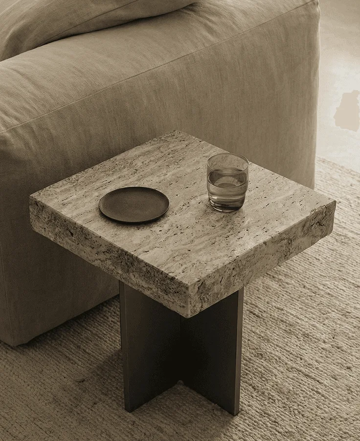 Travertine side table in soft window light (MCM House)